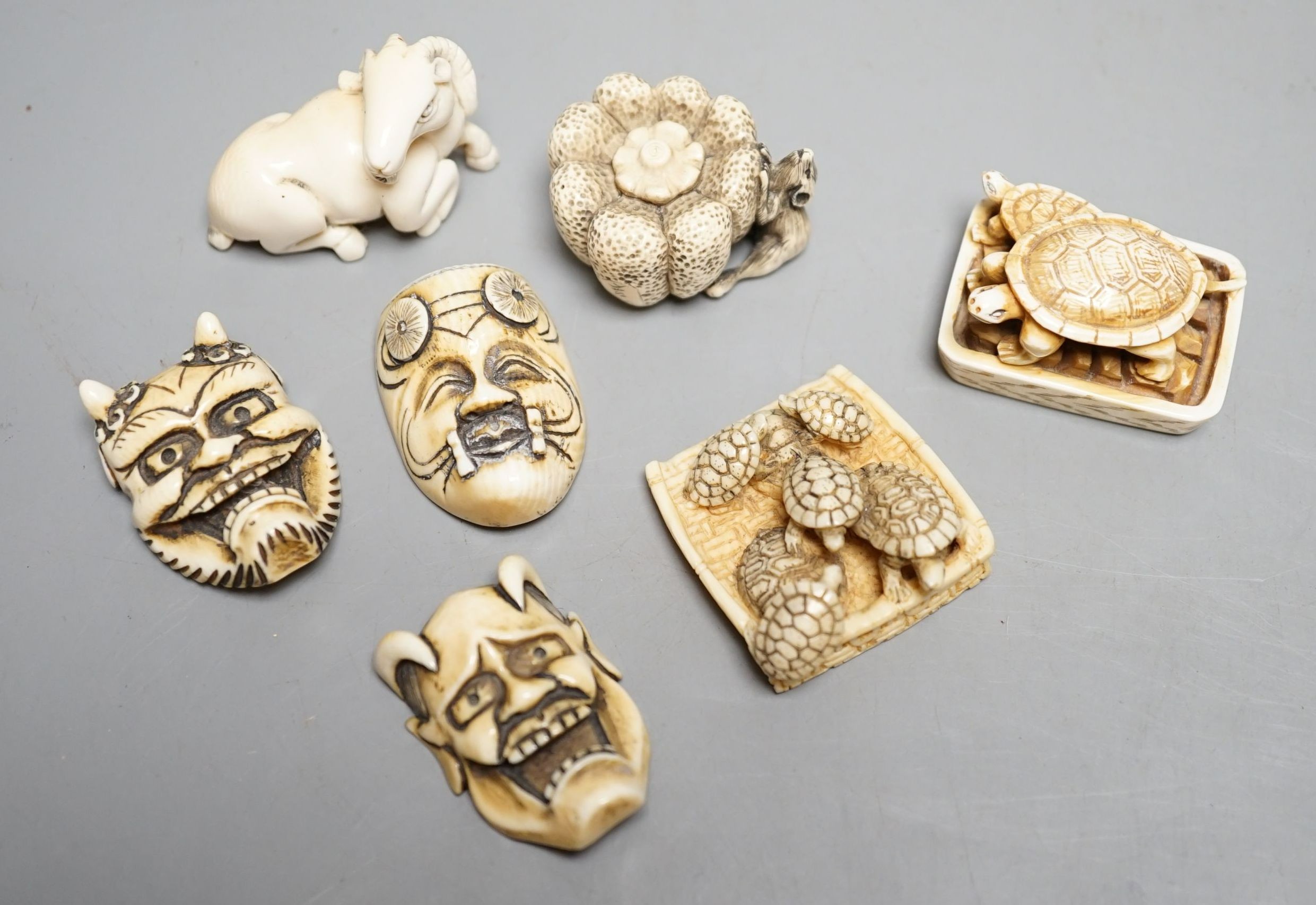 Seven Japanese ivory netsuke- three noh masks, two turtle groups, a ram, pumpkin and rats, Taisho/early Showa period, signed